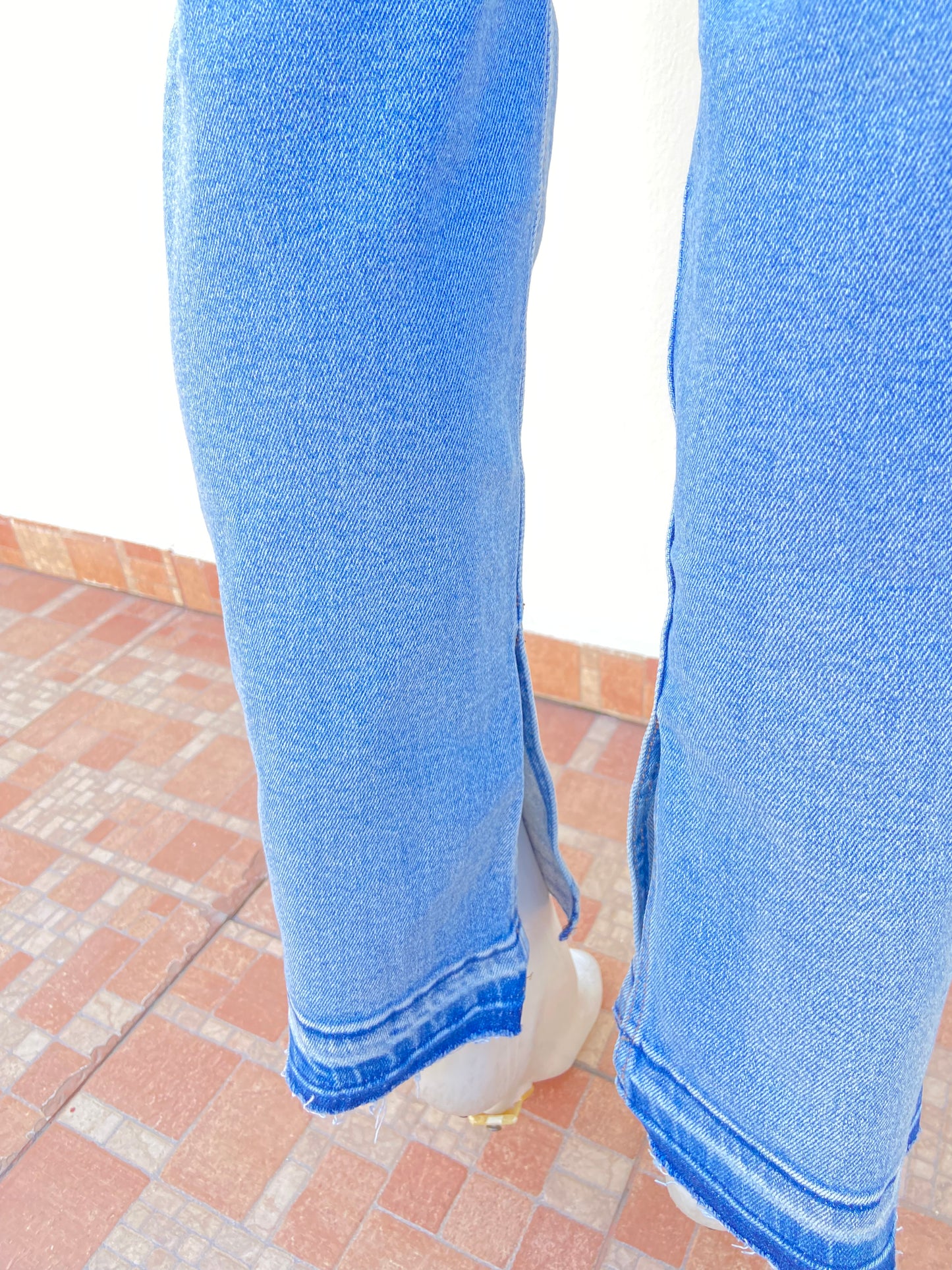 Pantalon Jean claro con degradado blanco con rasgados en las rodillas y abierto en los tobillos.