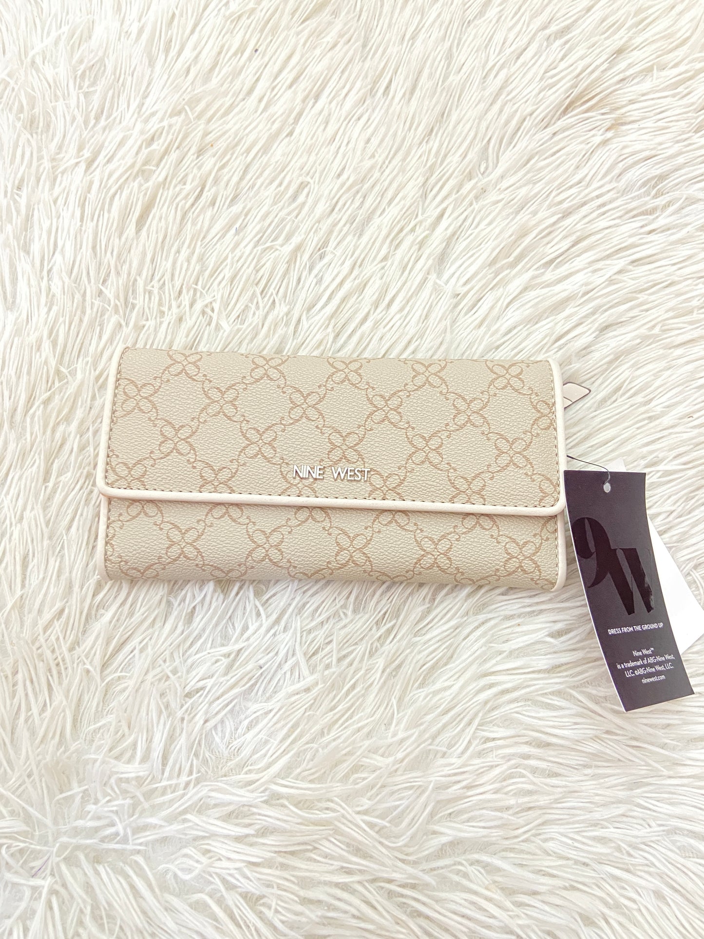 Monedero NINE WEST original crema con estampado de la marca y placa plateada.