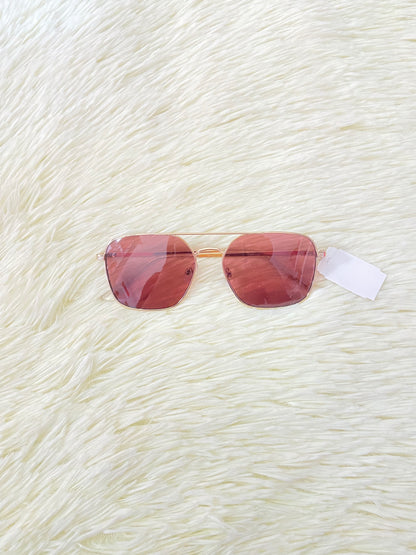 Lentes con montura metálica delgada con tono dorado/rosado, micas rosadas.