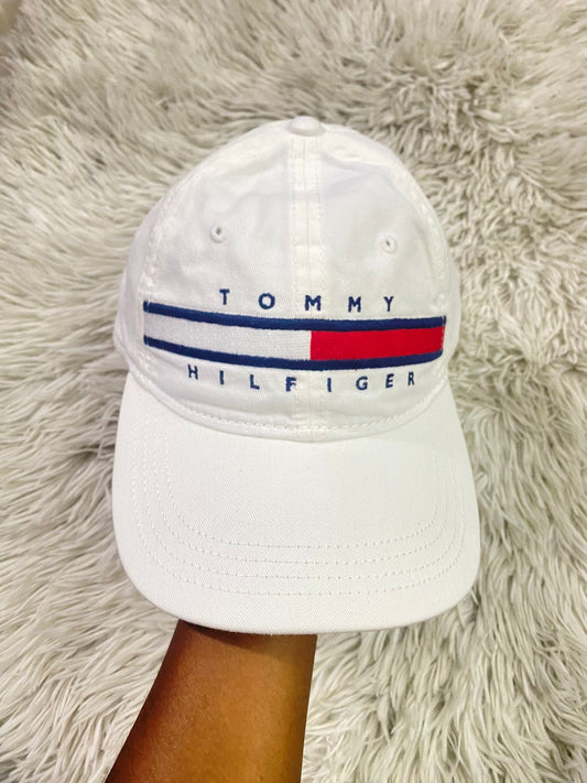 Gorra Tommy Hilfiger original blanca con logotipo de la marca en frente en azul marino y rojo.