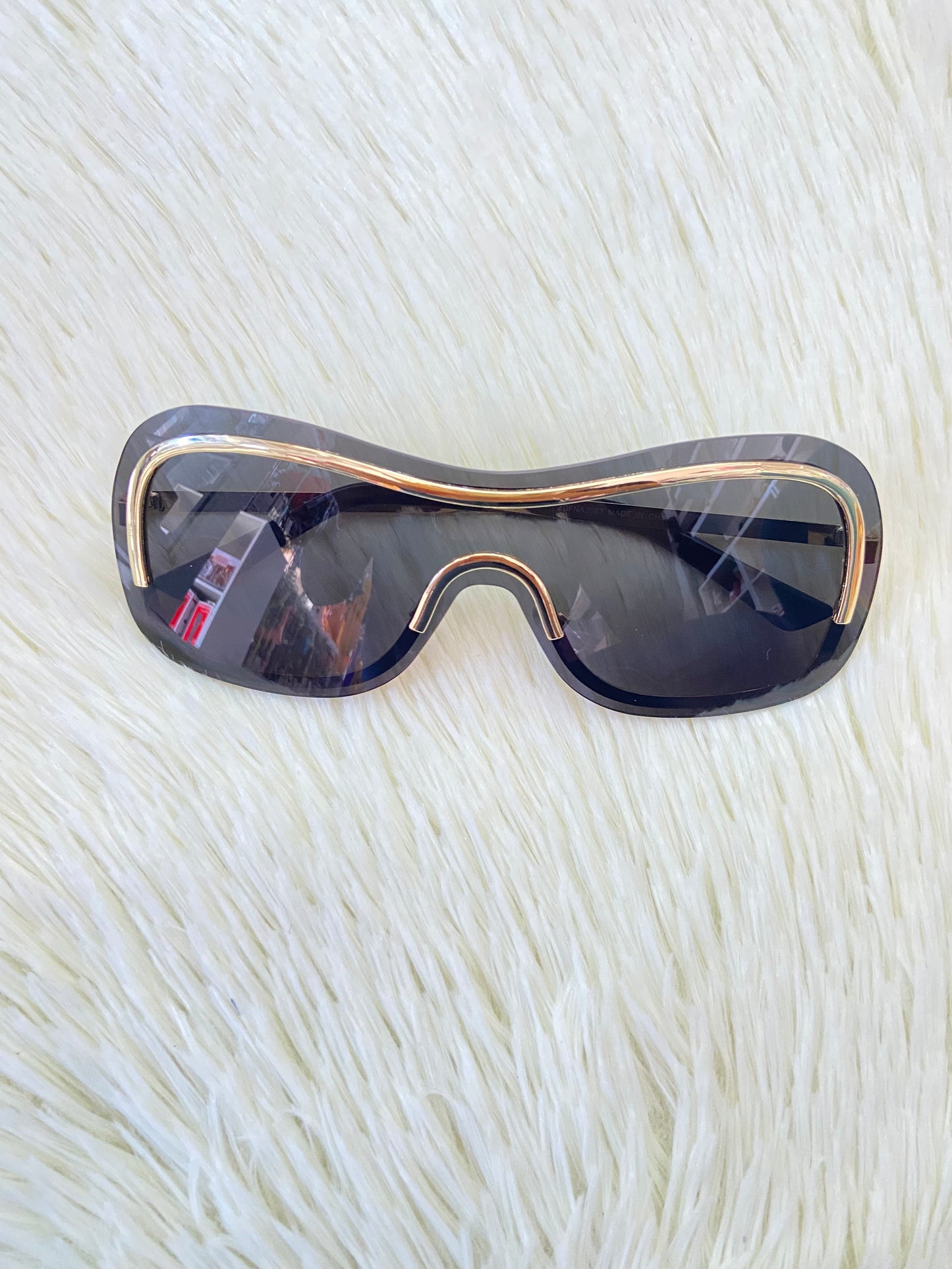 Lentes, negros, grandes curvos, con línea dorada al rededor y montura en  dorado.