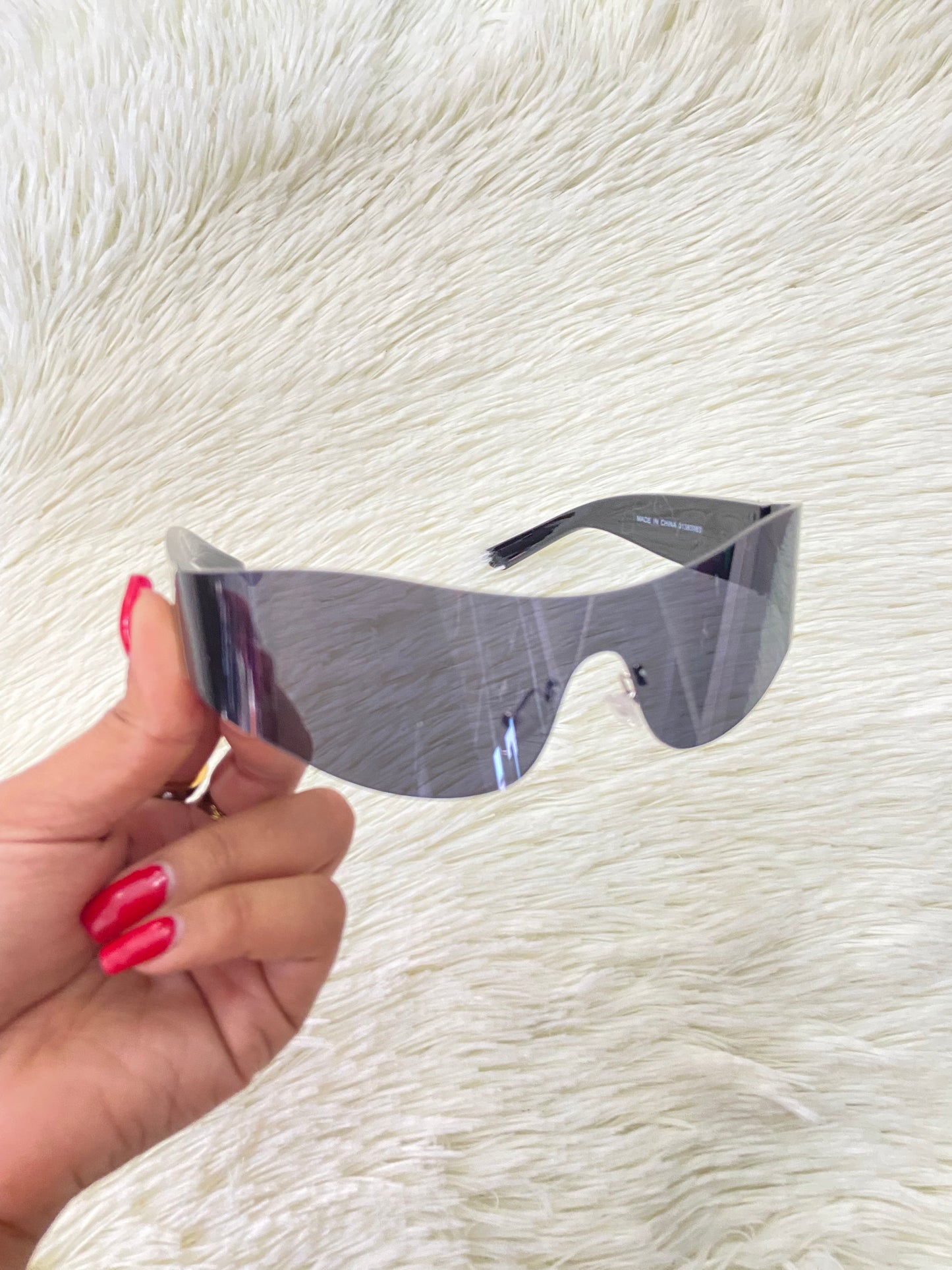 Lentes, negros curvos con detalles plateados en la montura.