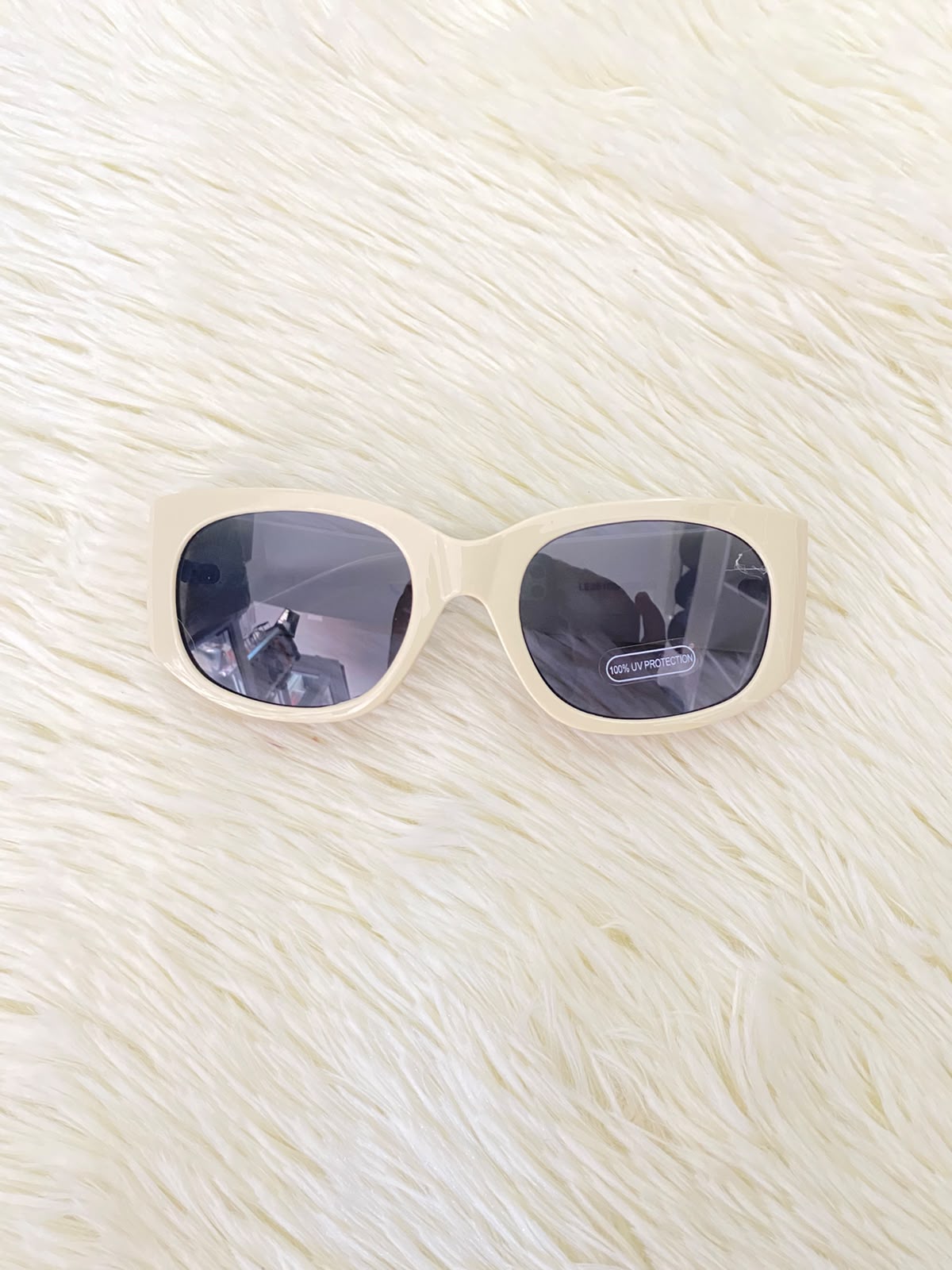 Lentes color crema con estampado de hojas tropicales en las patillas, estilo rectangular, con protección UV 100%.