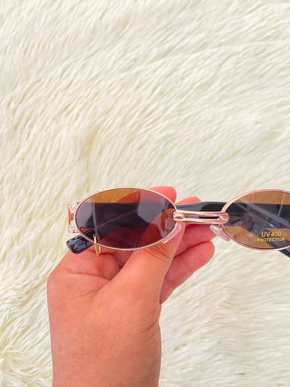 Lentes, negro con montura dorada, detalle de aro en un lente, estilo ovalado con protección UV 100-400