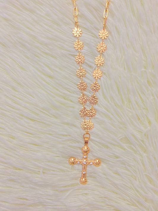 Cadena, dorada con dije en forma de cruz.