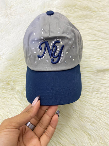 Gorra, gris con azul marino y letras NY y detalles de diamantes, para niños.