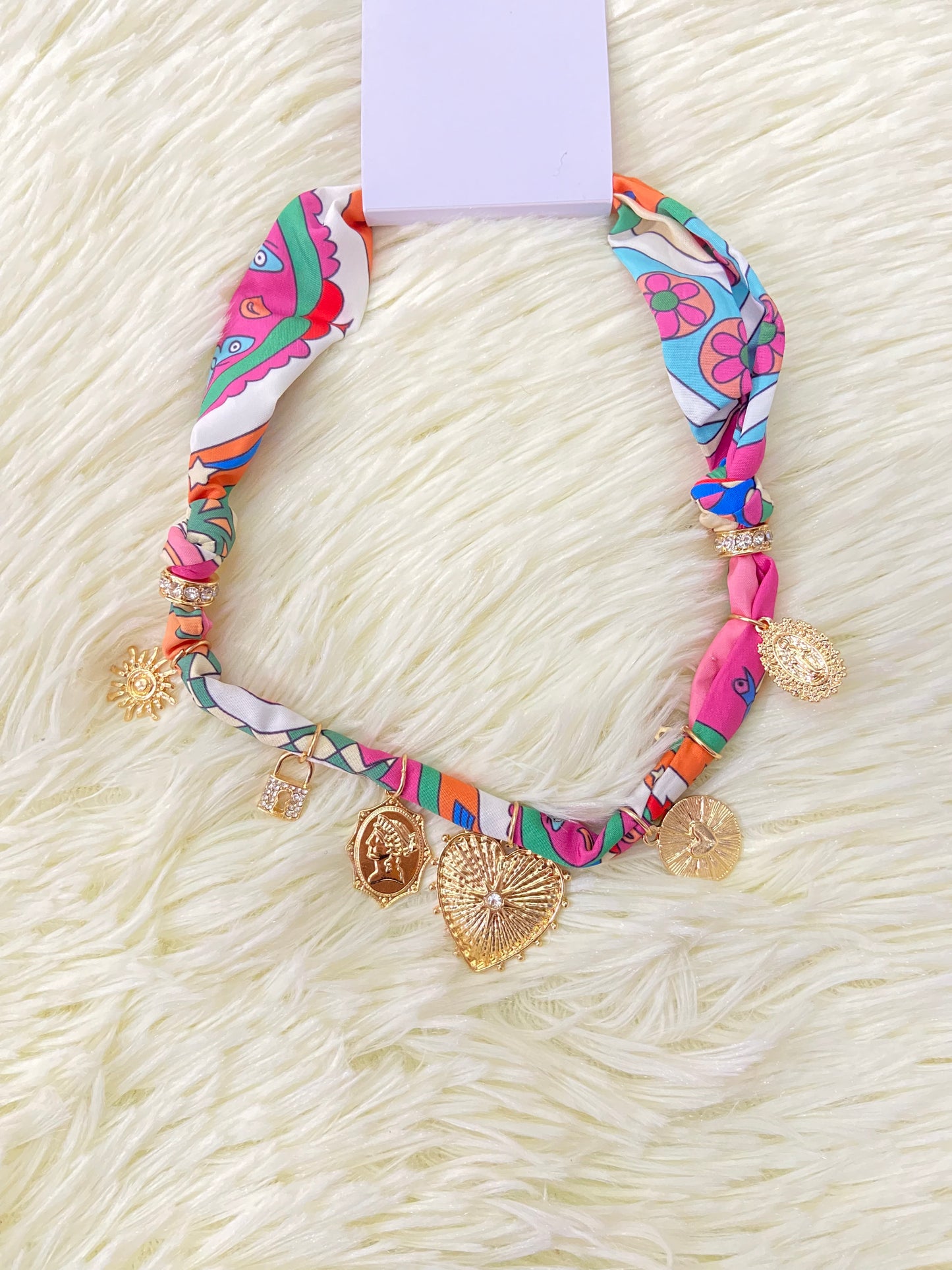 Collar de paño con accesorios colgantes de sol, corazones, la virgen entre otras.