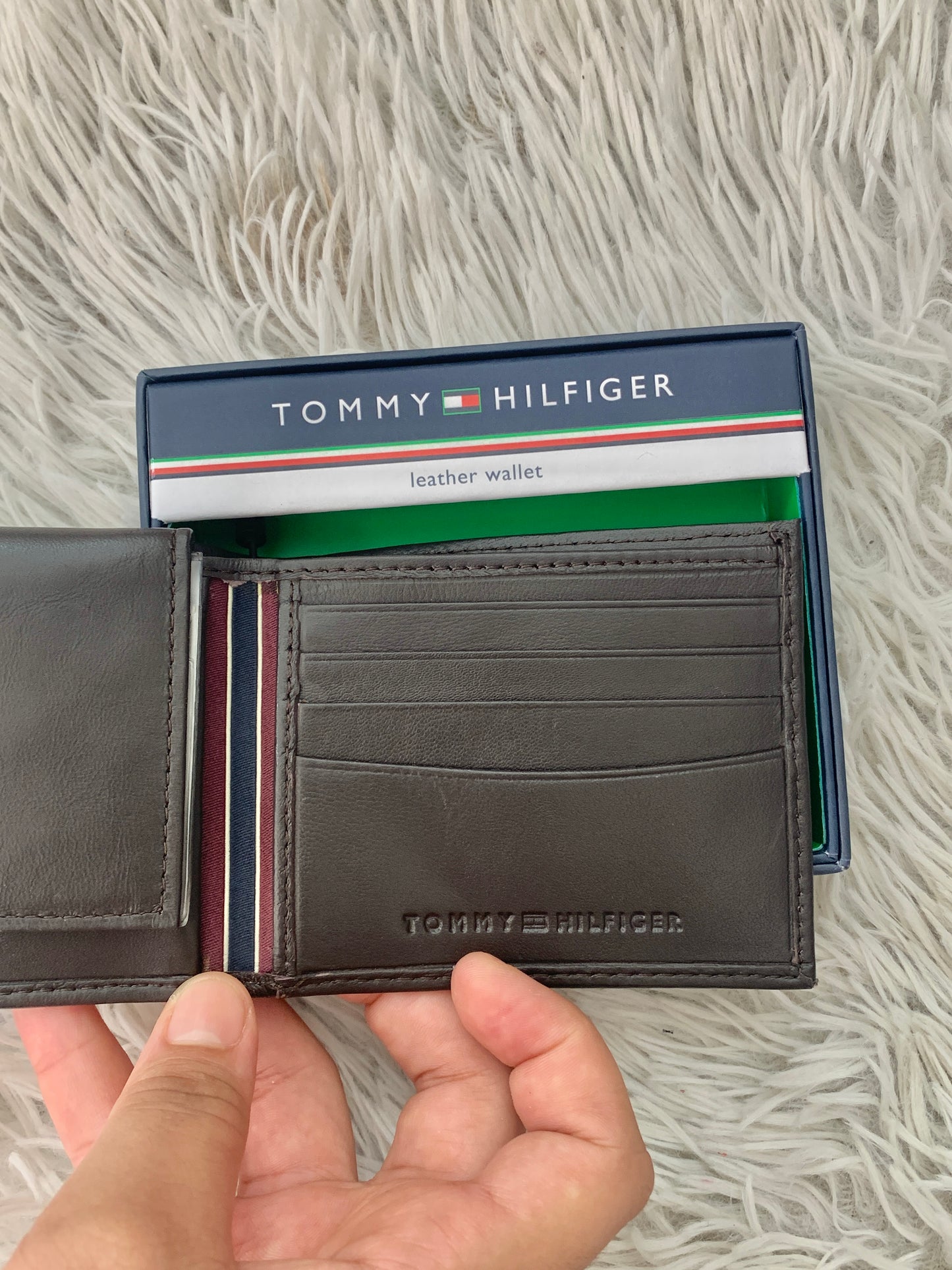 Billetera Tommy Hilfiger original marrón súper oscuro con letras HILFIGER al lado.