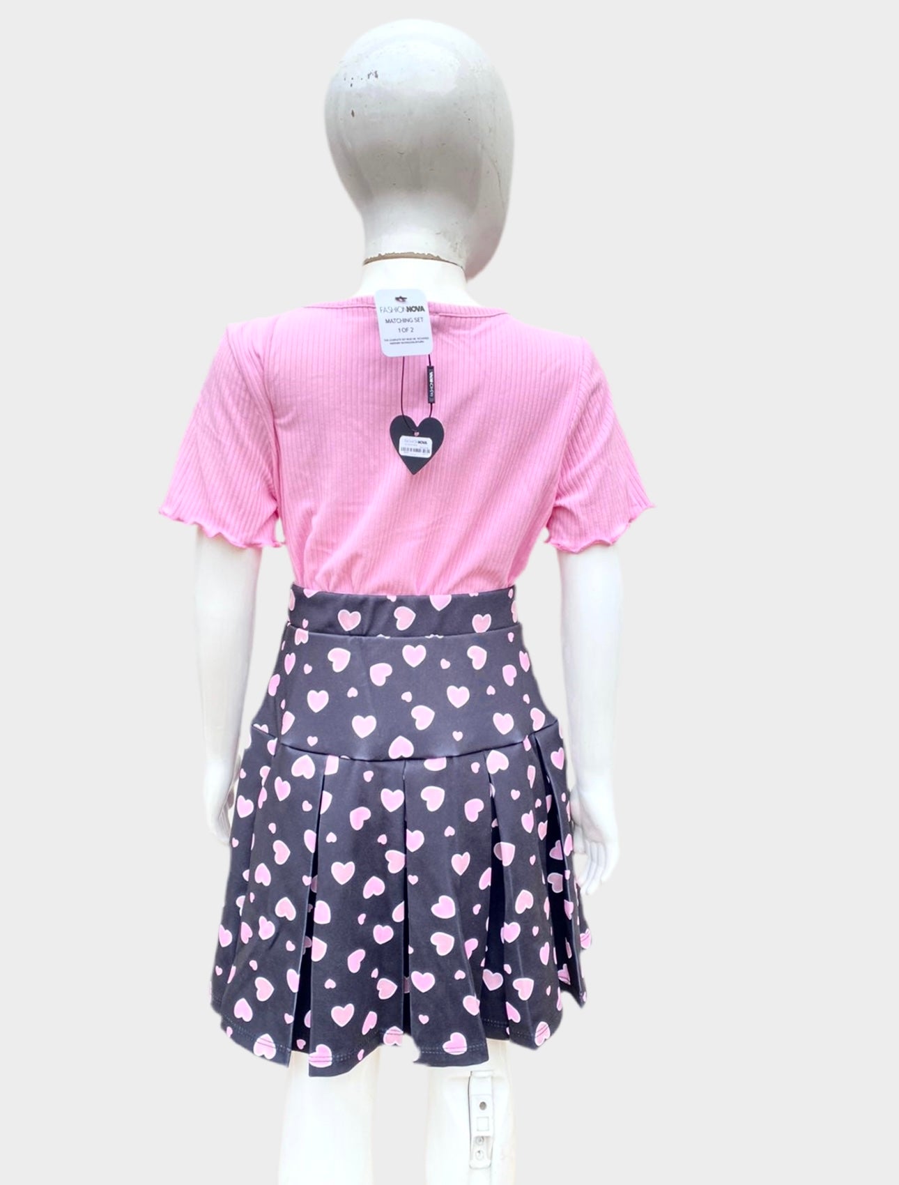 Conjunto niñas Fashion Nova Kid original de falda y top, rosado con negro y corazones en rosado.