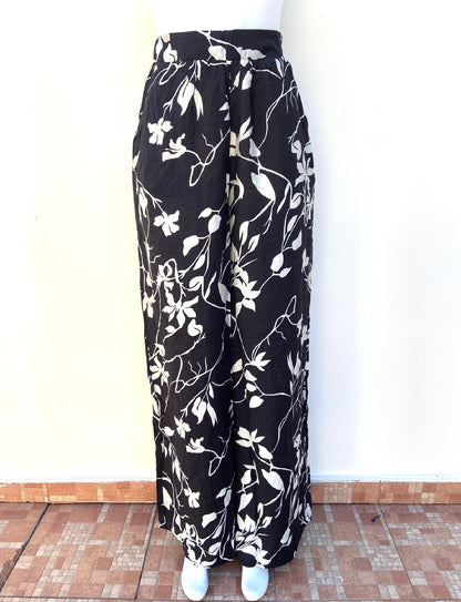 Pantalon Fashion Nova negro con estampados de flores blancas, estilo palazzo.