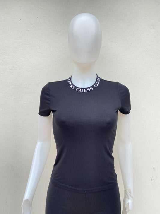 T Shirt GUESS original, en color negro y con nombre de la marca en color blanco alrededor del cuello.