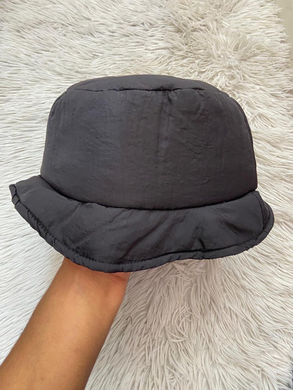 Gorro negro, impermeable con lazo ajustado en la parte trasera.