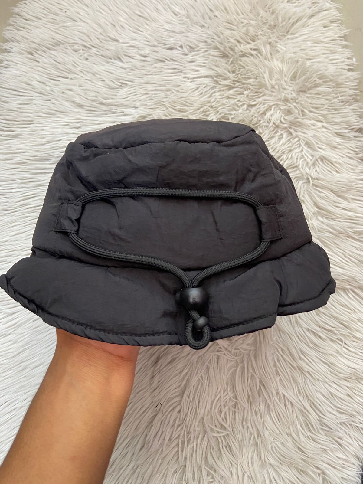 Gorro negro, impermeable con lazo ajustado en la parte trasera.