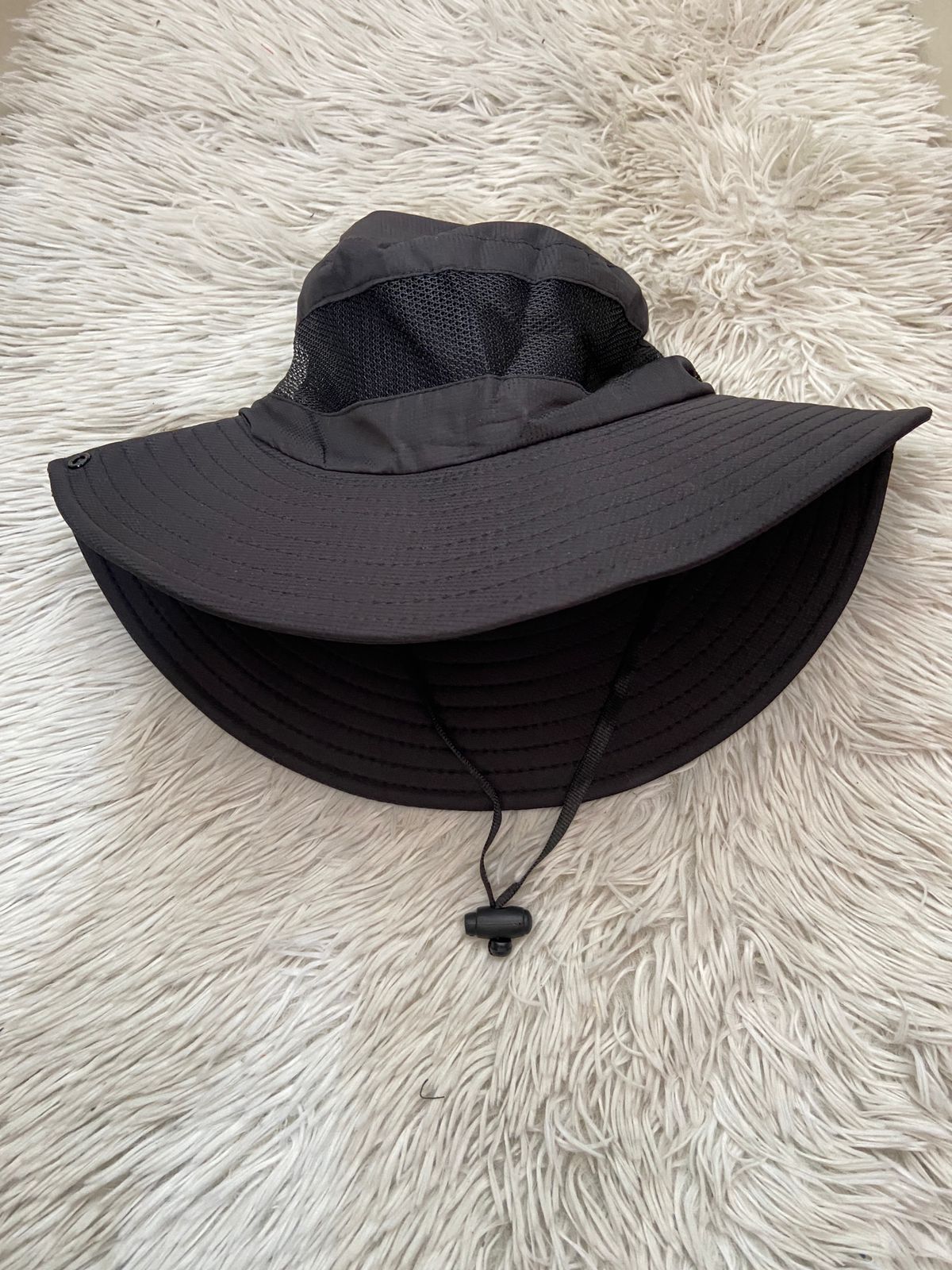 Gorro negro, con costura de hilo negro, con lazo ajustable.