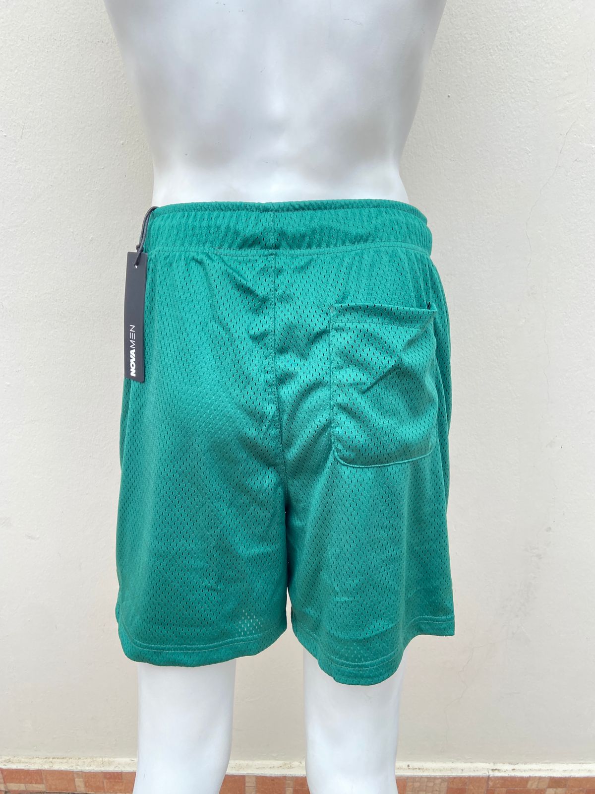 Bermuda deportiva verde, liso con lazo ajustable, con hoyitos.