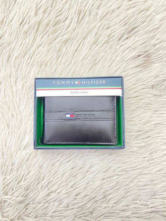 Billetera Tommy Hilfiger Original en color negro con logotipo y letra de la marca al frente y varios compartimientos
