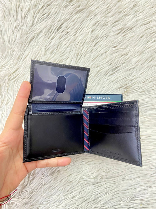 Billetera Tommy Hilfiger Original en color negro con logotipo y letra de la marca al frente y varios compartimientos