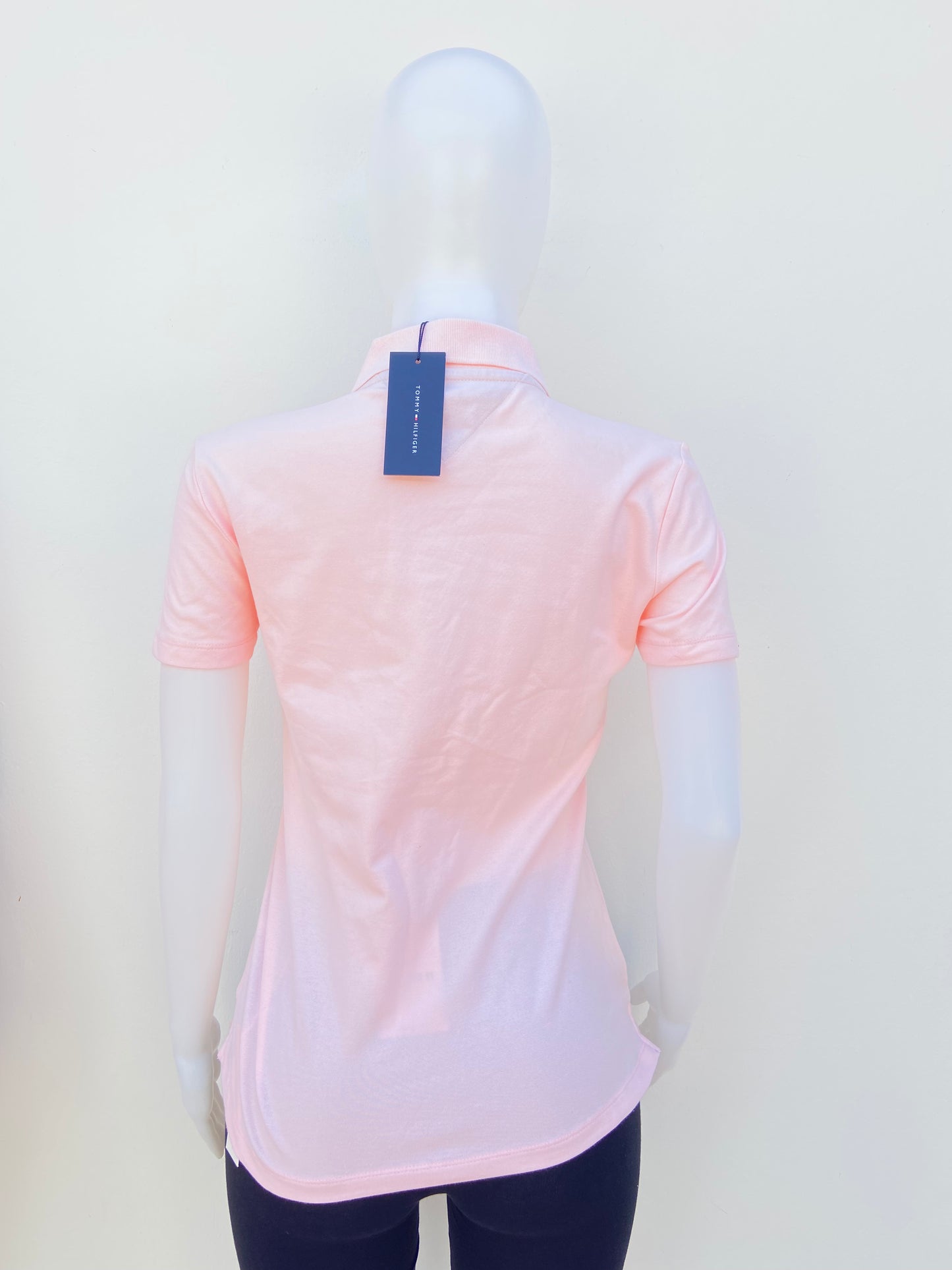 Polocher Tommy Hilfiger original rosado claro con botones en frente y logotipo de la marca.