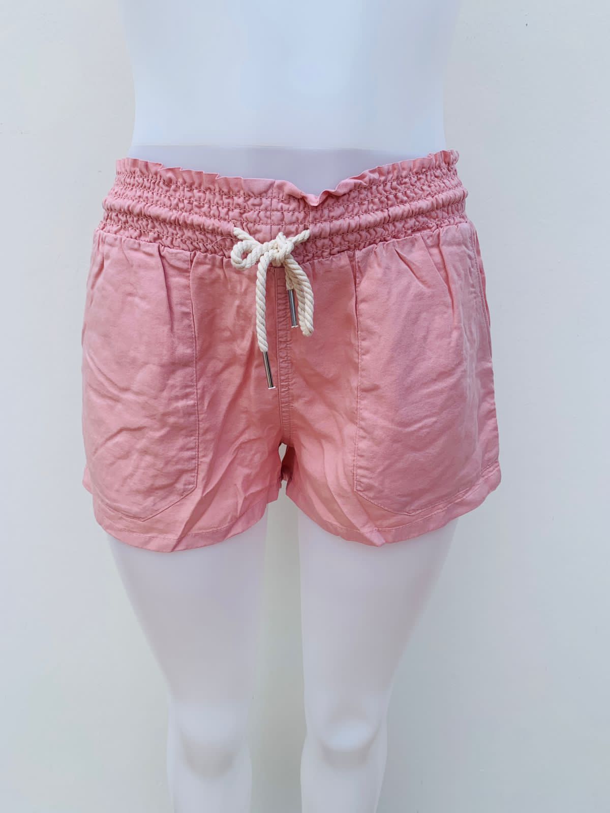 Short FASHION NOVA original, rosado opaco claro con cintura dobladilla y lazo ajustable en el centro estilo cordón de color crema.