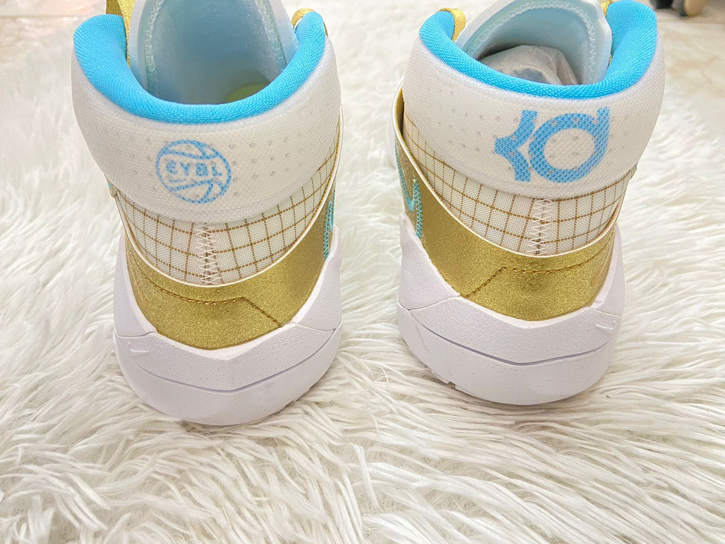 Tenis Nike original, altos blanco con dorado y rayas, con logotipo de la marca y cordones en dorado y azul por dentro.