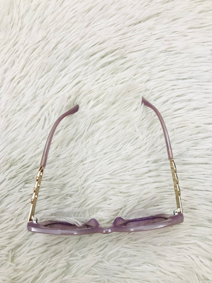 Lentes cuadrados grandes con montura morado claro y micas en cadena dorada. PROTECCIÓN UV 100