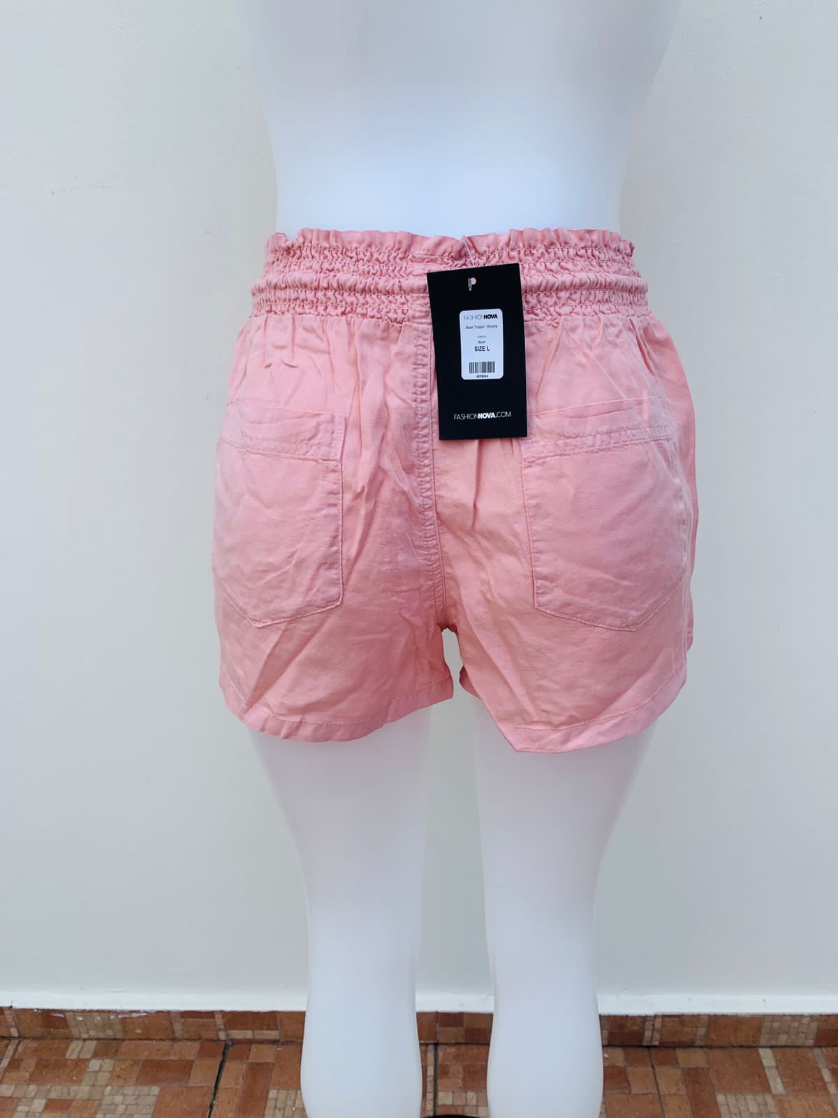 Short FASHION NOVA original, rosado opaco claro con cintura dobladilla y lazo ajustable en el centro estilo cordón de color crema.
