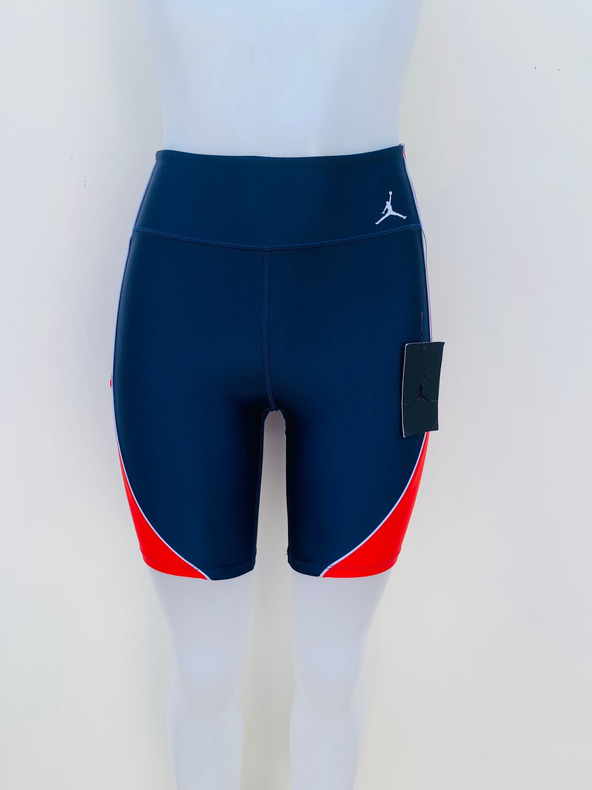 Legging/ Licra JORDAN original, azul marino con rayas rojas en los lados y pequeño logotipo de la marca en un lado en color blanco.