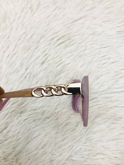 Lentes cuadrados grandes con montura morado claro y micas en cadena dorada. PROTECCIÓN UV 100