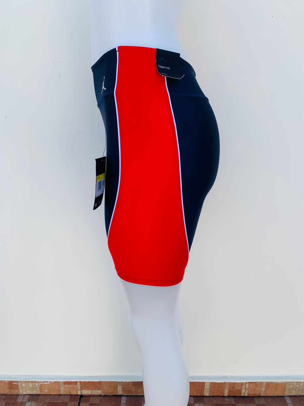 Legging/ Licra JORDAN original, azul marino con rayas rojas en los lados y pequeño logotipo de la marca en un lado en color blanco.