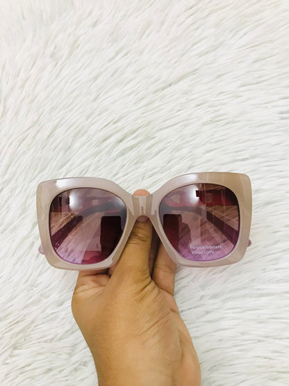 Lentes cuadrados grandes con montura morado claro y micas en cadena dorada. PROTECCIÓN UV 100
