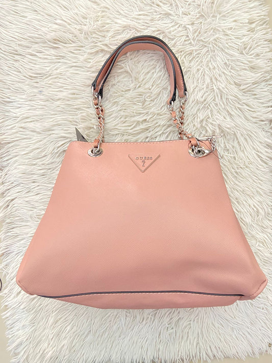 Cartera GUESS Original, color rosado pastel con logo en el centro y asas con cadena plateada.