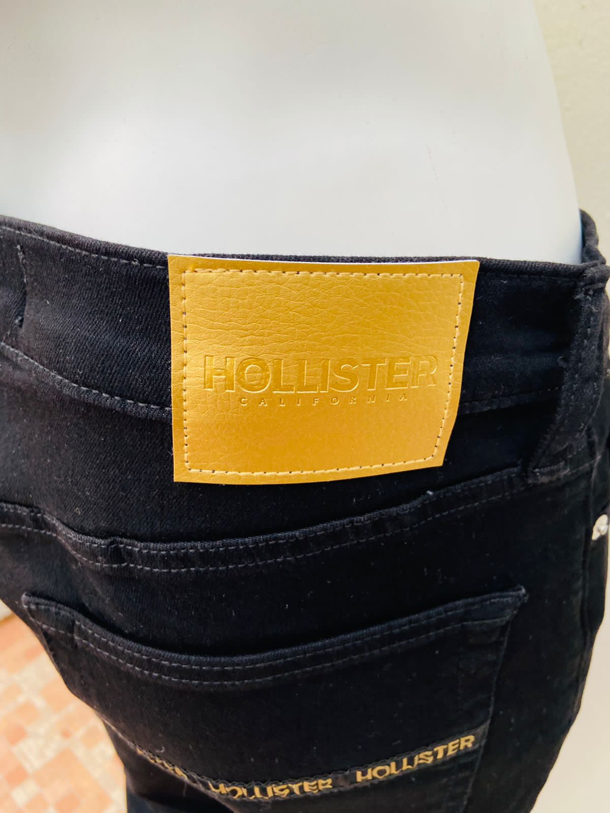 Pantalón Hollister original, negro con rasgado en las rodillas, letras HOLLISTER en color dorado en los bolsillos