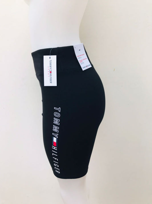 Legging licra Tommy Hilfiger original de color negra talle alto con diseño de letras y logo TOMMY HILFIGER en blanco de lado