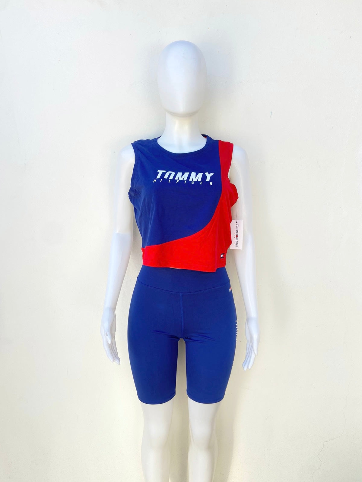 Conjunto Tommy Hilfiger original legging antes la rodilla y top sin mangas azul con rojo y letras TOMMY HILFIGER en blanco.