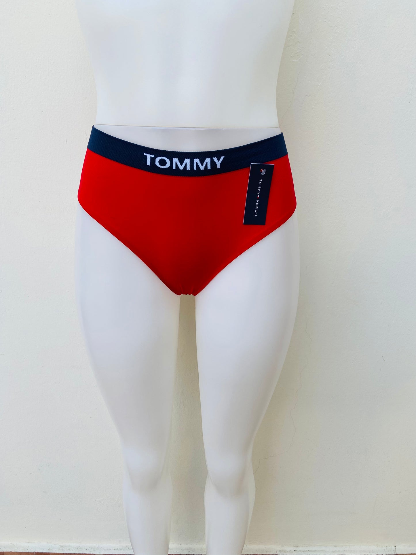 Panti Tommy Hilfiger original rojo con banda en color azul marino y letras TOMMY en blanco.