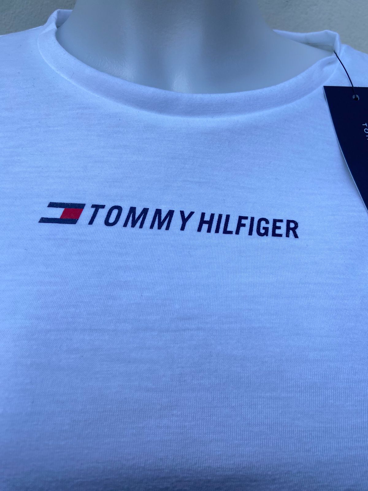 Blusa Tommy Hilfiger original, blanco con nudo en el centro y letras TOMMY HILFIGER con pequeño logotipo de la marca en el centro.