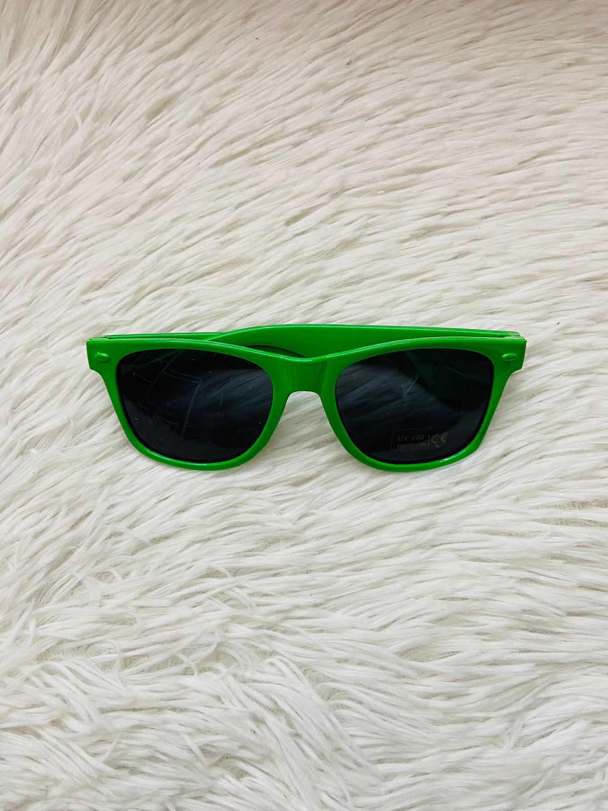 Lentes, con montura verde lisa con cristales negros, UV400 PROTECCIÓN.