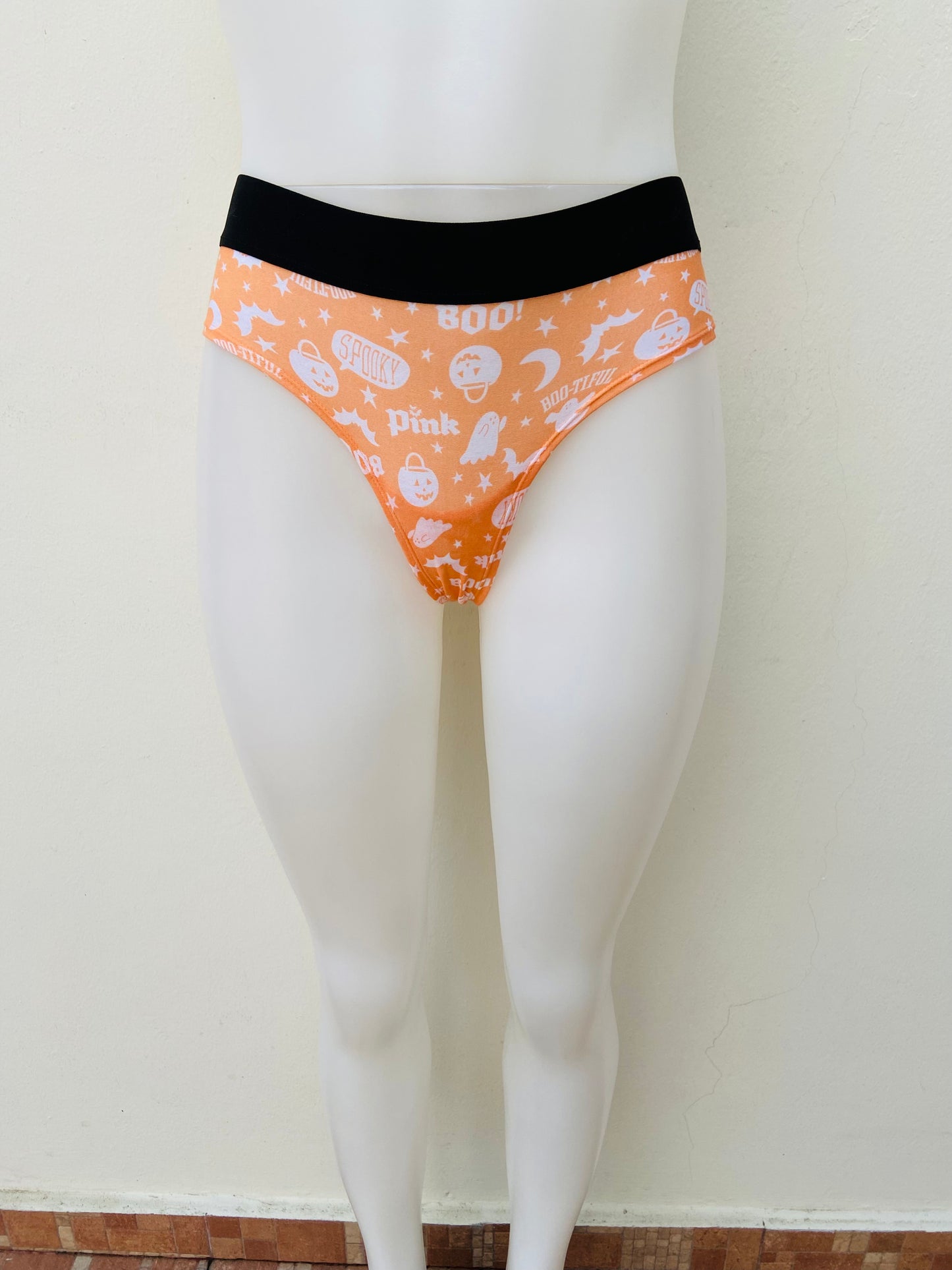 Panti Victoria’s Secret PINK Original naranja con estampado de calabazas y diseños de hallowen y pretina en color negro.
