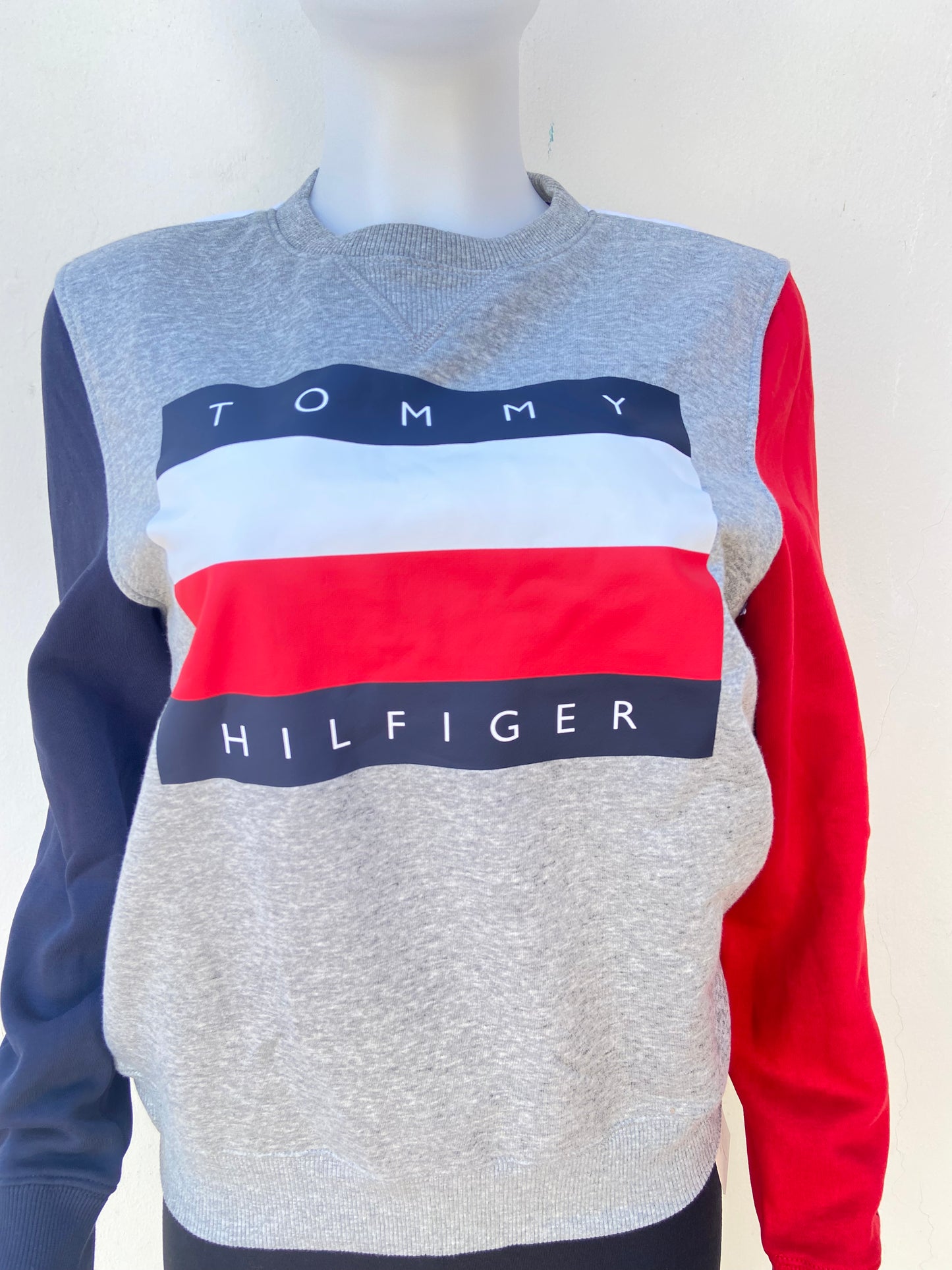 Sueter / Abrigo  Tommy Hilfiger original gris con mangas en color rojo y azul marino y estampado con letras TOMMY HILFIGER con la banda de Tommy, manga larga.