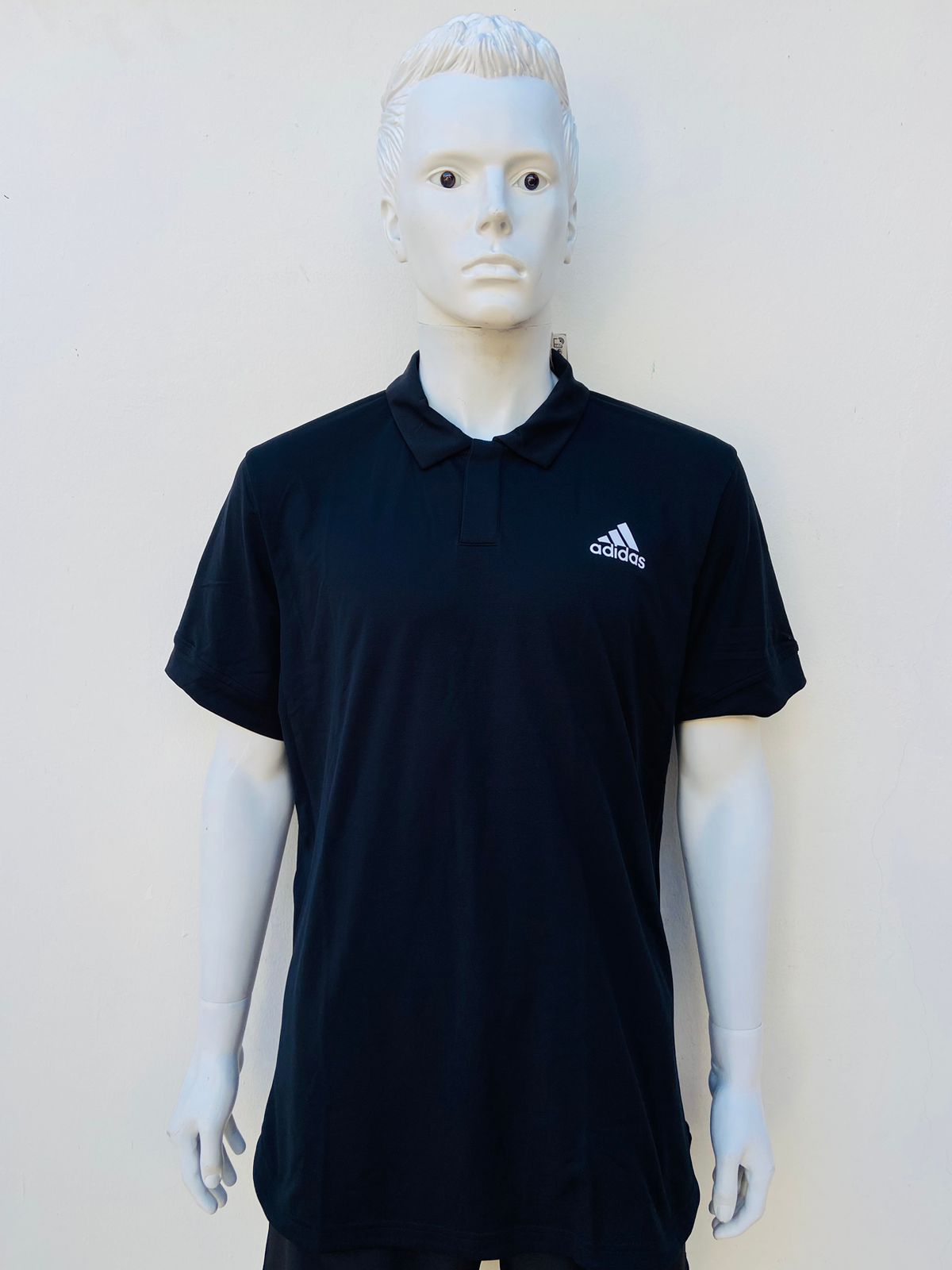 Polocher Adidas original en color negro con pequeño logo tipo de la marca y letras ADIDAS